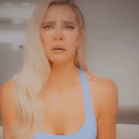 A Woman In A Blue Tank Top Is Crying . GIF
