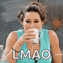 A Woman In A Blue Tank Top Is Drinking A Cup Of Coffee And Making A Funny Face . GIF