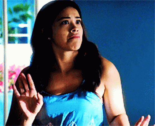 A Woman In A Blue Tank Top Is Making A Face GIF