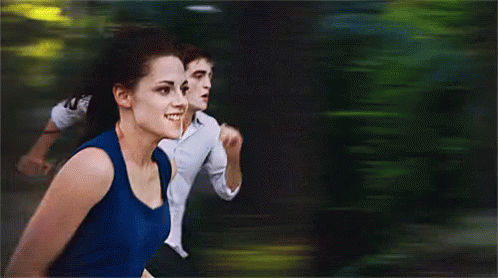 A Woman In A Blue Tank Top Is Running With A Man In A White Shirt GIF