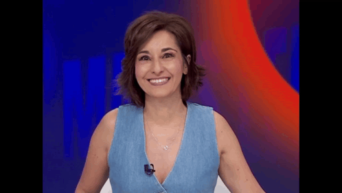a woman in a blue tank top is smiling and wearing a microphone .