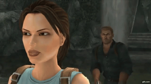 A Woman In A Blue Top Is Standing Next To A Man In A Black Jacket With The Letter B On The Back GIF