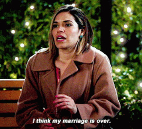 a woman in a brown coat is sitting on a bench and saying i think my marriage is over