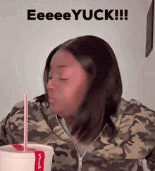 a woman in a camo jacket drinking from a cup with a straw and the words eeeeyuck