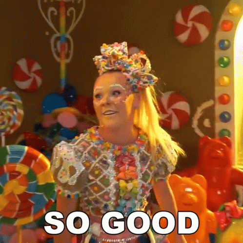 A Woman In A Candy Costume Says So Good In Front Of Candy GIF