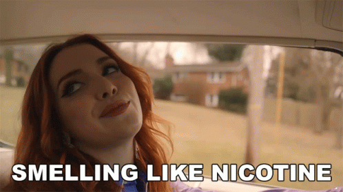 A Woman In A Car With The Words Smelling Like Nicotine GIF
