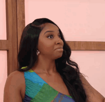 A Woman In A Colorful Dress Is Making A Surprised Face GIF