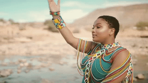a woman in a colorful dress is waving her hand