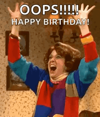 A Woman In A Colorful Sweater Is Raising Her Arms In The Air . GIF