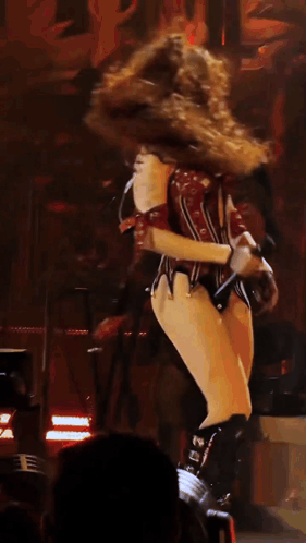 A Woman In A Corset Is Dancing On A Stage In Front Of A Keyboard GIF