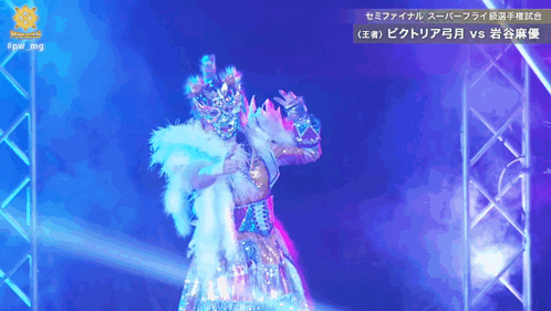 A Woman In A Costume Is On A Stage In Front Of A Sign That Says #Qw Img GIF