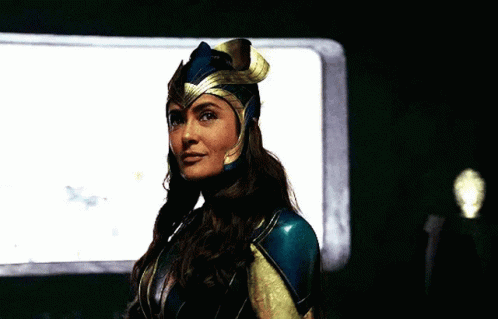 A Woman In A Costume Is Standing In Front Of A Window And Looking At The Camera . GIF