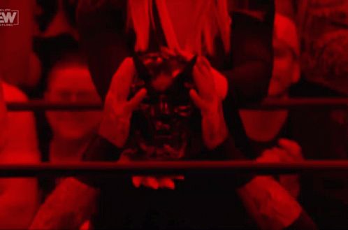A Woman In A Cowboy Hat Stands In A Dark Room With A Ew Logo In The Corner GIF