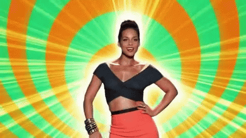 A Woman In A Crop Top And A Red Skirt Is Standing In Front Of A Colorful Circle . GIF