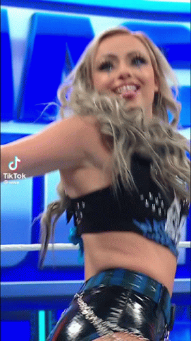 A Woman In A Crop Top And Shorts Is Dancing In A Ring . GIF