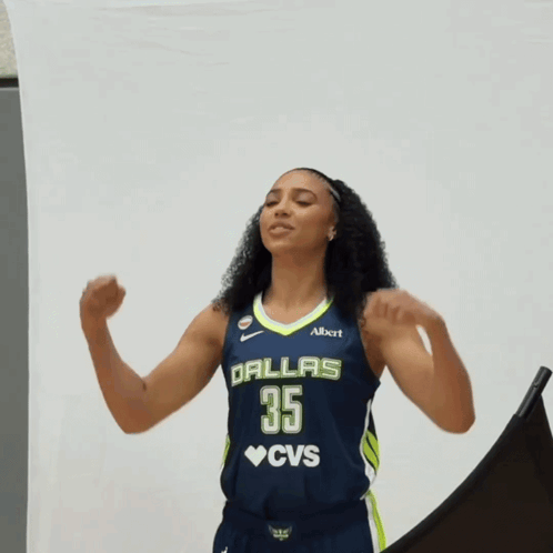 A Woman In A Dallas 35 Cvs Jersey Flexes Her Arms GIF