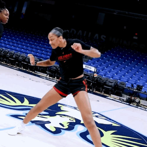 A Woman In A Dallas Warriors Shirt Stands On A Court GIF