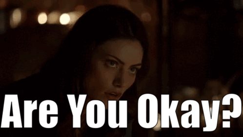 A Woman In A Dark Room With The Words " Are You Okay " On The Bottom GIF