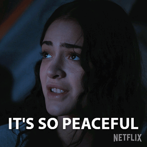 A Woman In A Dark Room With The Words It 'S So Peaceful Written Above Her GIF