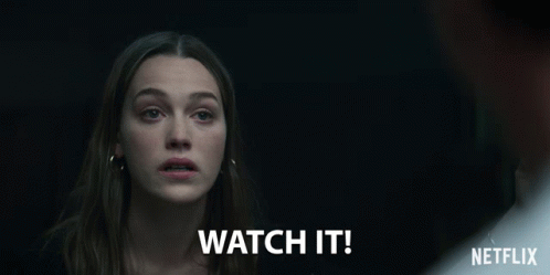 A Woman In A Dark Room With The Words Watch It Written Below Her GIF