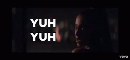 A Woman In A Dark Room With The Words Yuh Yuh On The Bottom GIF