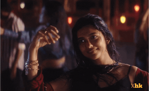 A Woman In A Dark Room With Xhk Written On The Bottom GIF