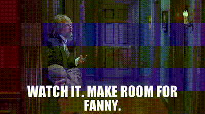 A Woman In A Denim Jacket Is Standing In A Doorway With The Words Watch It Make Room For Fanny Written Above Her . GIF