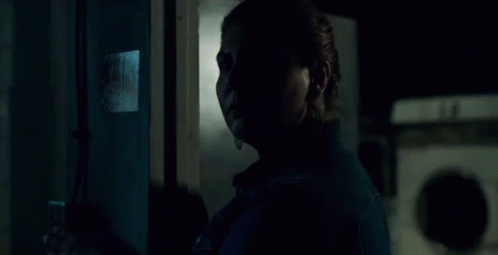 a woman in a denim jacket stands in front of a fire extinguisher