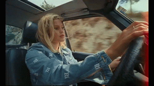 A Woman In A Denim Jacket With The Letter B On It GIF