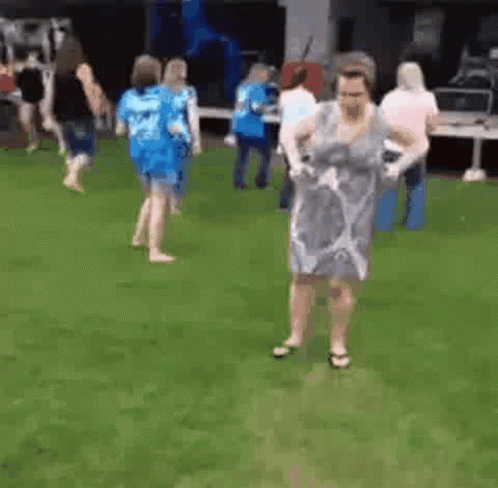 Woman Dancing In Grass With Others GIF