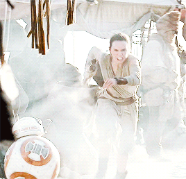 A Woman In A Dress Is Fighting A Bb-8 Robot GIF
