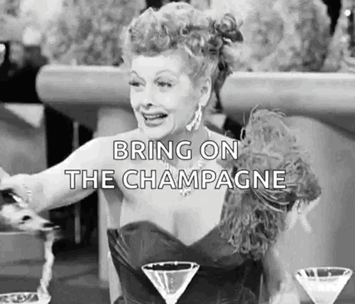 A Woman In A Dress Is Sitting At A Table With Two Martini Glasses And A Glass Of Champagne . GIF