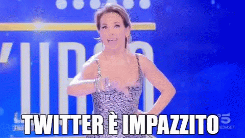 a woman in a dress is standing in front of a blue background that says twitter e impazzito