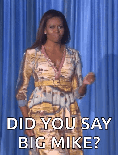 A Woman In A Dress Is Standing In Front Of A Blue Curtain And Asking Did You Say Big Mike GIF