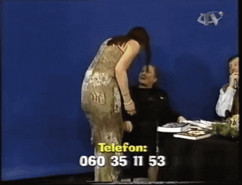 a woman in a dress is standing in front of a blue screen with a phone number written on it