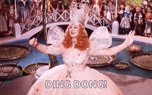 A Woman In A Fairy Costume Is Holding A Wand In Her Hand . GIF