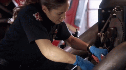 A Woman In A Firefighter Uniform Is Working On A Machine With A Ctv Logo In The Background GIF