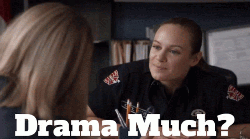 A Woman In A Firefighter Uniform Talks To Another Woman With The Words Drama Much Below Her GIF