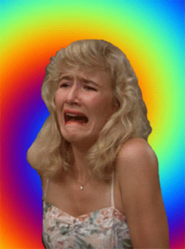 A Woman In A Floral Dress Is Crying Against A Rainbow Background GIF