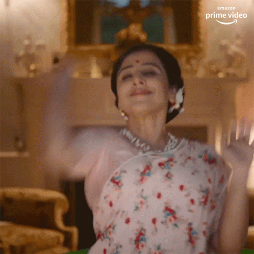 A Woman In A Floral Dress Is Dancing In A Living Room With The Amazon Prime Video Logo Visible GIF