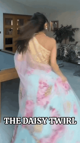 A Woman In A Floral Dress Is Dancing In A Room With The Words The Daisy Twirl Above Her GIF