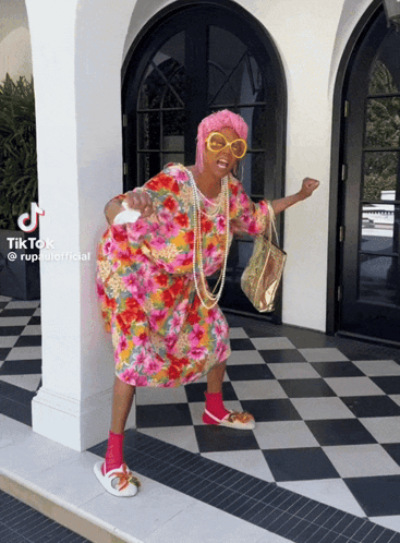 a woman in a floral dress is standing in front of a checkered floor with tiktok written on the bottom