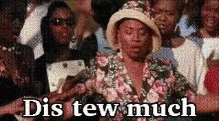 A Woman In A Floral Shirt And Hat Is Standing In A Crowd Of People And Says Dis Tew Much . GIF