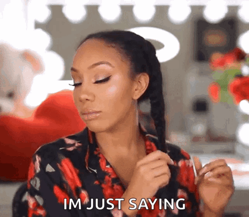A Woman In A Floral Shirt Is Holding Her Hair And Saying Im Just Saying GIF