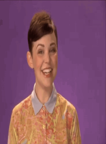 a woman in a floral shirt says shana tova on a purple background