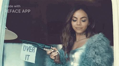 a woman in a fur coat is holding a gun and a sign that says `` over it '' .