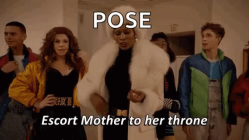 A Woman In A Fur Coat Is Standing In Front Of A Group Of People In A Room . GIF