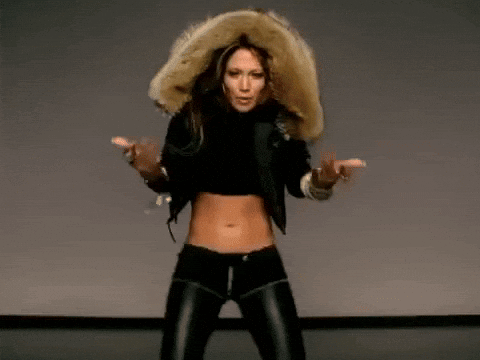 A Woman In A Fur Hooded Jacket Is Dancing On A Stage . GIF