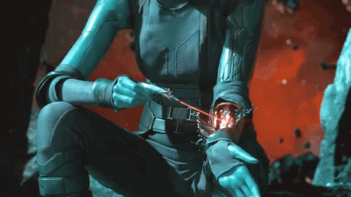 A Woman In A Futuristic Outfit Is Holding A Red Object In Her Hand GIF