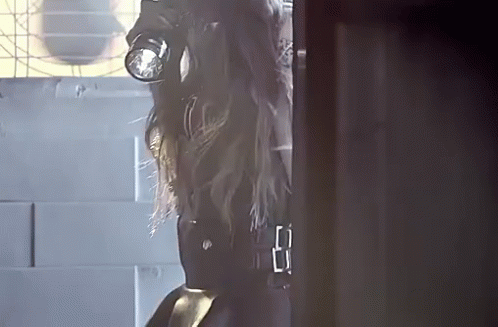 a woman in a gas mask is standing in a doorway